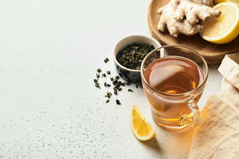 Ginger tea. Cup of ginger tea with lemon, honey and mint on grey background. Concept alternative med