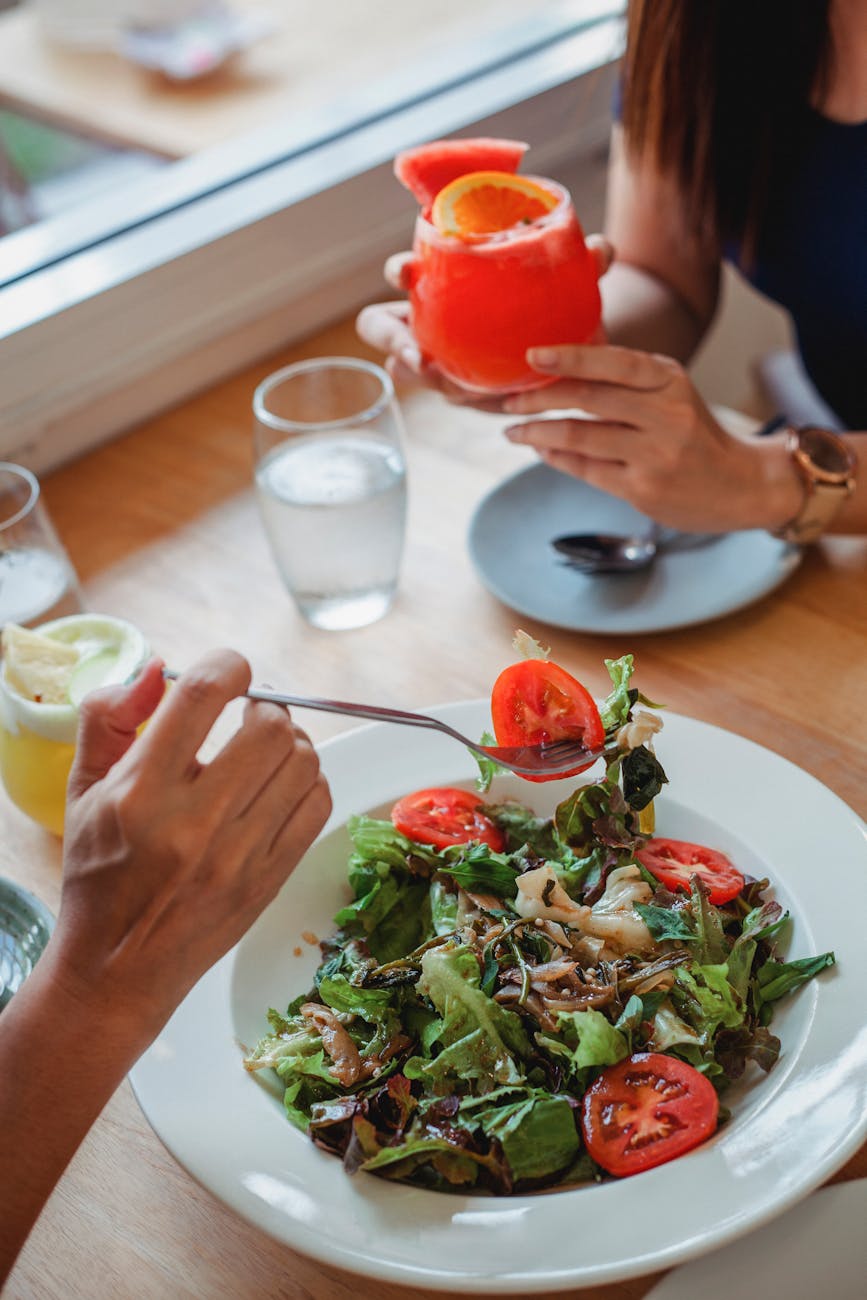 crop person eating salad in restaurant