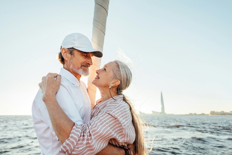 Side view of elderly people embracing outdoors at sunset