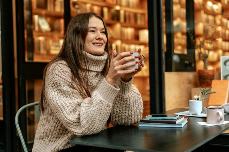 Stylish young woman drinking coffee at the coffee shop